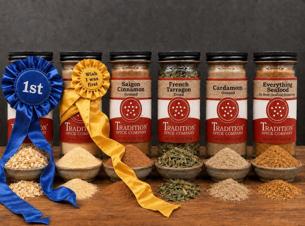 Red chili peppers and crushed chili flakes spell out the word FAVES on a rustic wooden background, with whole chilies forming the letter V.