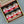 Box of spice jars with red and white labels on a gray background