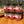 Six jars of ground spices from Tradition Spice Company on a wooden surface with a blurred natural background.