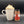 A white ceramic mug filled with a whipped hot drink and a sprinkle of cinnamon, standing next to a glass jar of Tradition Spice Company Ceylon Cinnamon Ground on a dark gray background.