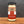 A glass jar of Tradition Spice Company Garlic Powder on a wooden surface against a dark gray background.