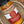 A close-up of a glass jar of Tradition Spice Company ground turmeric spice, showing the orange-yellow powder and label, resting inside a rustic ceramic bowl.