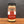 A glass jar of Tradition Spice Company Brownnulated Sugar with a black lid, set on a wooden surface against a dark gray background.