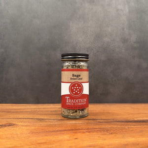 Spice jar labeled 'Tradition Spice Company' on a wooden surface with a gray background