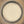A top-down view of a light beige powder, likely flour or cosmetic powder, inside a clear glass jar with a silver metal rim.