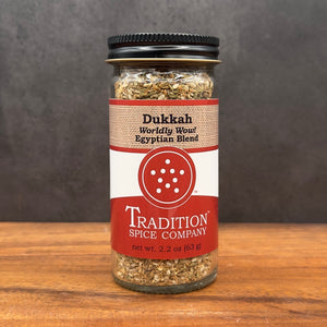 A jar of Dukkah, Worldly Wow! Egyptian Blend sits on the table, showcasing a fragrant mix of Middle Eastern spices.