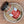 A jar of Sizzl’n Lime, Da Best! Chili Lime Seasoning sits in a shallow ceramic bowl on a wooden surface. The jar features a red label and black lid and holds a zesty chili lime spice blend.