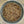 Top view of a glass jar filled with coarse, speckled Sizzl’n Lime, Da Best! Chili Lime Seasoning, featuring grains of salt, pepper, and red pepper flakes. The background is a blurred, neutral-toned surface.
