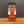A glass jar of Tradition Spice Company Turkish Spice, featuring a black lid and a red, white, and beige label, set on a wooden surface against a dark gray background.