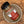A bottle of Tradition Spice Company Turkish Spice Bold Turkish Blend resting inside a ceramic bowl on a textured wood background.