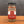 A glass jar of Tradition Spice Company Best Bruschetta Italian Appetizer Mix, featuring a red and white label with a black lid, set on a wooden surface against a dark gray background.