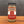 A glass jar of Tradition Spice Company Taste of Tuscany Bread Dip Mix, filled with a dried herb and spice blend, set on a wooden surface against a dark gray background.