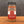 A glass jar of Tradition Spice Company Honey Aleppo Pepper Dry Rub Seasoning, featuring a black metal lid and a red and white label, set on a wooden surface against a dark gray background.