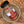 A bottle of Tradition Spice Company Honey Aleppo Pepper Dry Rub Seasoning resting on a rustic ceramic dish over a wood grain surface.