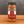 A glass jar of Tradition Spice Company Honey Habanero Dry Rub Seasoning sits on a wooden surface against a dark gray background.
