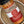 A close-up of a spice rub seasoning bottle labeled 'Honey Habanero Dry Rub Seasoning' by Tradition Spice Company, resting inside a rustic ceramic bowl.