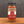 A glass jar of Tradition Spice Company St. Louis Ribs Dry Rub Seasoning, filled with reddish-brown spice rub and topped with a black lid, set on a wooden surface against a dark gray background.