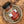A bottle of Tradition Spice Company Kansas City BBQ Dry Rub Seasoning resting inside a small rustic ceramic dish on a wood grain surface.