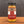 A glass jar of Tradition Spice Company Carolina Gold BBQ Dry Rub Seasoning sits on a wooden surface against a dark gray background.