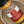 A close-up of a spice jar labeled Carolina Gold BBQ Dry Rub Seasoning by Tradition Spice Company, resting inside a metal bowl.