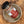 A bottle of Tradition Spice Company Austin Steak Dry Rub Seasoning resting on a rustic metal plate over a wood grain surface.