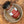 A glass jar of Tradition Spice Company Colorado Cowboy BBQ Dry Rub Seasoning, featuring a black lid and a label with red, white, and burlap textures, resting on a rustic ceramic plate over a wood grain surface.