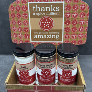 The Welcome Home Gift Box includes jars of salt, black pepper, and garlic mix from Tradition Spice Company—must-have kitchen staples. A sign says, “Thanks a spice million! Now go season something amazing.”.