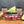 A Guac Me Up! Guacamole Maker’s Kit featuring four seasoning jars is displayed on a wooden surface, surrounded by guacamole, tortilla chips, and avocado halves.