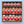 A gift box of 16 jars of Tradition Spice Company whole spices, arranged in four rows of four on a light blue background.