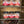 Jars of Traditions seasoning on a metal shelf with a roasted piece of meat below.