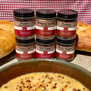 Jars of Tradition Spice Company spices with bread and soup in the background