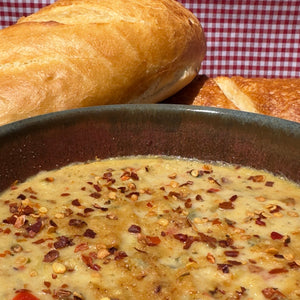 Bowl of soup with bread on a checkered tablecloth