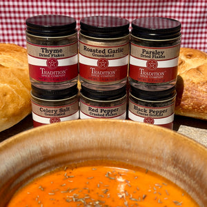 Jars of Tradition Spice Company spices with a bowl of soup in the foreground.